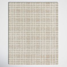 a white and beige square rug with squares on it, in front of a white wall