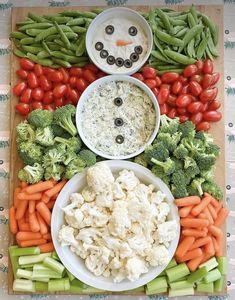 vegetables and dips arranged in the shape of a snowman