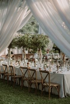 the tables are set with white linens and greenery