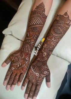 two hands with henna tattoos on them