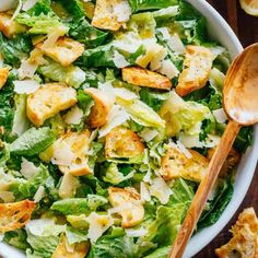 a white bowl filled with lettuce and croutons