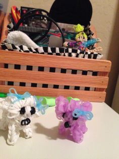 two small plastic animals sitting next to each other on a table in front of a basket