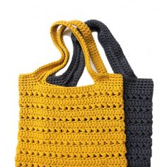 two crocheted bags with handles are shown in yellow and blue, one is black