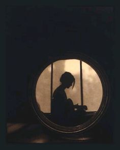 a person sitting in front of a round window