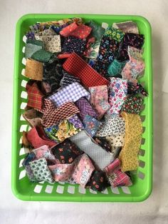 a green basket filled with lots of different types of ties