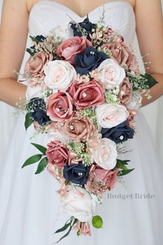 a bridal holding a bouquet of pink and blue flowers with greenery on the side