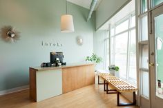 an empty room with a bench in front of the window and a large open door