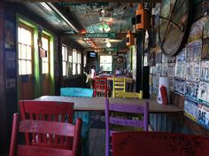 the inside of a restaurant with colorful chairs