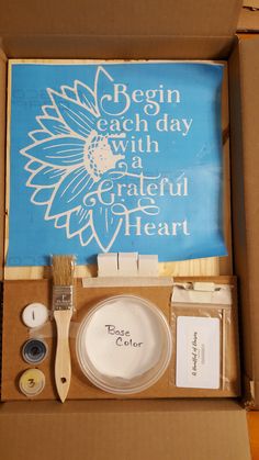 an open box with some crafting supplies in it and a sign that says begin each day with a grateful heart