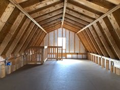 an empty attic with wooden walls and beams