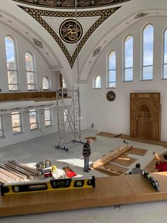 the inside of a building being constructed with wooden planks and other construction equipment on display