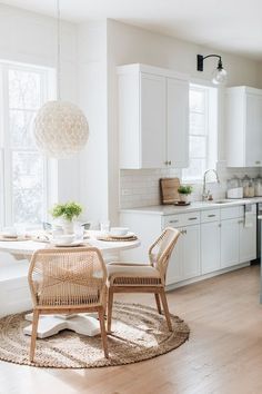 the kitchen is clean and ready to be used for dinner or breakfast time, with all white furniture