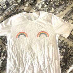 White Cotton Tshirt With Small Rainbows On Chest. Never Worn. Cotton T-shirt With Rainbow Print For Pride, Trendy Cotton T-shirt With Rainbow Print, Trendy Rainbow Top For Pride, Trendy Rainbow T-shirt For Spring, Fun Rainbow Print Short Sleeve Top, Trendy Rainbow T-shirt For Pride, Trendy Rainbow Pride T-shirt, Rainbow Print Tops For Pride, Pride Graphic Print Crew Neck Top