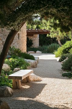 a white bench sitting in the middle of a gravel path next to trees and bushes