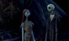 two skeletons standing next to each other in a cave