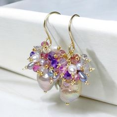 Baroque Pearl Earrings, Pink Tourmaline Amethyst Cluster Earring, Gold Fill Earrings, Rainbow Metallic Earrings, Romantic Wedding Earrings Beautiful, rainbow metallic hued baroque pearls, mounted on 14 kt yellow gold filled wires, dangle beneath clusters of gemstones and pearls in pinks, gold, lavender, purple and gray hues reflecting the colors in the pearls' nacre to create these romantic pearl earrings. Gems of pink tourmaline, purple and pink amethyst and pink tourmaline and more cluster wit Purple Briolette Earrings For Wedding, Briolette Gemstone Earrings For Wedding, Amethyst Gemstone Wedding Earrings, Amethyst Gemstone Earrings For Wedding, Amethyst Drop Earrings For Wedding, Amethyst Multi-stone Briolette Earrings, Handmade Amethyst Wedding Earrings, Amethyst Multi-stone Drop Earrings, Amethyst Earrings With Gemstone Accents For Wedding