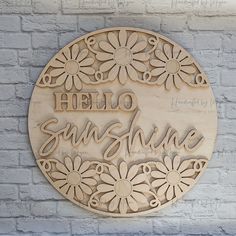 a wooden sign that says hello sunshine with daisies in the center on a brick wall