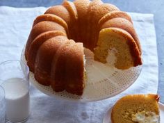 a bundt cake on a plate with a slice cut out next to it and a glass of milk