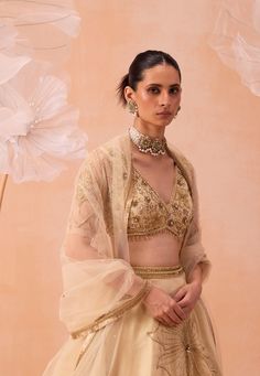 An elegant set features a V-neck blouse embellished with intricate zardozi floral motifs, paired with a lehenga adorned with large floral motifs and a matching dupatta. The ensemble combines sophisticated detailing with timeless charm, making it a perfect choice for any special occasion. Pre Bridal, Lehenga Pattern, White Lehenga, Lehenga Red, Organza Lehenga, Padded Blouse, Indian Wedding Wear, Elegant Sets, Silk Organza