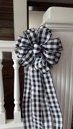 a black and white checkered bow hanging from the side of a stair railing with stairs in the background