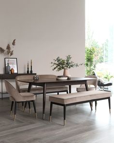 a dining room table with benches and chairs in front of it on a hard wood floor