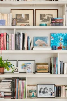 a bookshelf filled with lots of different types of books and pictures on it