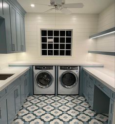 a washer and dryer in a room with blue cabinets on either side of the door