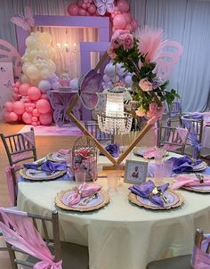 the table is set with pink and purple decorations