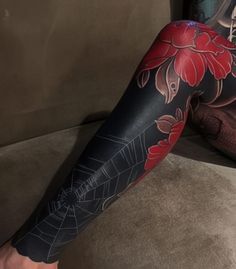 a woman's leg with tattoos on it and a red flower in the center