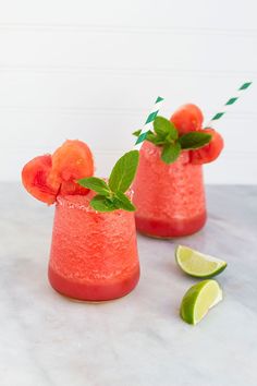 two glasses filled with watermelon and limeade garnished with mint leaves