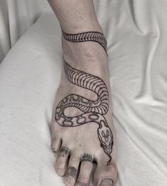 a person's foot with a tattoo on it and a snake on the bottom