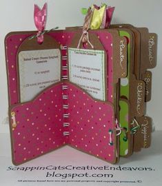 the inside of a book is decorated with pink and brown polka dot paper, which has two small tags attached to it