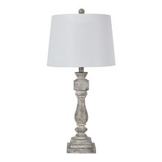 a lamp that is on top of a white table cloth with a white shade over it