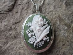 "Beautiful cameo lockets The cameo is a gorgeous lily of the valley. Stunning colors, I have these in so many pretty colors and finishes, as well as in barrettes, necklaces, brooches and so much more to complete the look. The bronze and silver plated lockets are Victorian style with beautiful etching on both the front and back about 2\" long. They can hold two photos or a treasured keepsake. Pass down from generation to generation The bronze locket includes a 24\" rolo link chain with a lobster White Wedding Locket Jewelry, White Engraved Jewelry For Wedding, White Engraved Wedding Jewelry, Flower Shaped Locket Jewelry For Wedding, Floral Wedding Locket Jewelry, Wedding Flower Locket Jewelry, Flower Shaped Wedding Locket Jewelry, Green Locket Wedding Jewelry, Green Locket Jewelry For Wedding