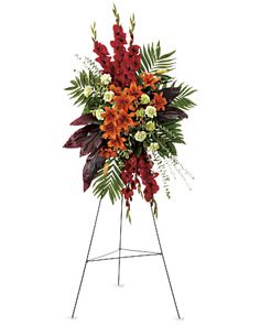 an arrangement of red and white flowers in a metal stand