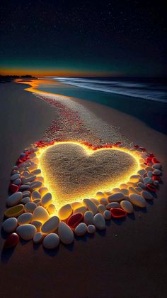 a heart made out of rocks on the beach at night with stars in the sky