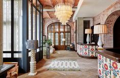 a large room with wooden floors and brick walls, decorated in an ornate pattern on the ceiling