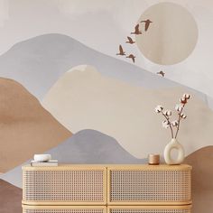 a living room scene with focus on the sideboard and wall papered mural behind it