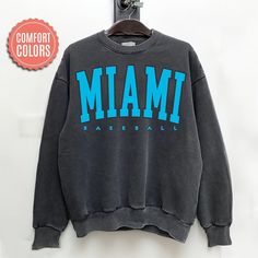 Comfort Colors Miami Baseball Sweatshirt, Miami Baseball Sweater, Vintage Style Miami Baseball Shirt, Miami Baseball fan Gift -Please check Color and Size Charts before placing the order. You can find them in the listing's photos (Depending on what device you are viewing this listing colors may vary slightly). -Returns and exchanges are accepted only if there are defects "No Extra Costs" We create custom t-shirts with great designs for everyone's liking. If you don't find the size or color you w Throwback Crew Neck Top For Game Day, Throwback College Tops With Logo Print, Throwback Crew Neck Top For Sports Season, Throwback Crew Neck Tops For College, Throwback Sports Season Tops With Relaxed Fit, Throwback Long Sleeve Tops With Letter Print, Gray College-style Top With Letter Print, Throwback Relaxed Fit Tops For Game Day, Relaxed Fit Throwback Tops For Game Day