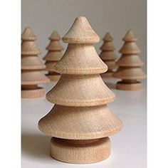 several wooden christmas trees lined up on a white surface with one standing out from the others