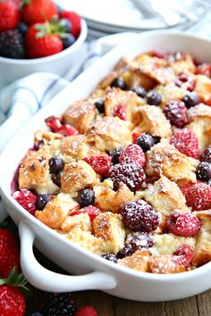 a casserole dish with berries and powdered sugar in it on a table