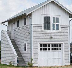 a two car garage with stairs leading up to the second floor and an attached porch