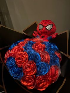 a spiderman bouquet made out of red, white and blue roses in a box