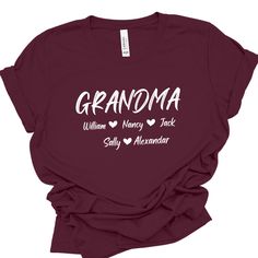 Show your love and pride with our personalized Grandma T-shirt featuring the names of your beloved grandkids. This shirt is not just clothing; it's a heartfelt connection to your cherished grandchildren, keeping them close to your heart wherever you go.  * Gildan Soft Style   unisex shirts.  * Rolled sleeves in pictures is for styling purposes only. * This design will be made with DTF film print. * Printed in the USA. SIZE  * Take a look at the photos to see specific sizing chart for this shirt Family Matching Short Sleeve T-shirt For Personalized Gift, Customizable Tops For Father's Day, Custom Text T-shirt For Family Gatherings, Customizable Tops For Father's Day Gift, Customizable Family Matching T-shirts For Family Gatherings, Custom Family Matching T-shirts For Family Gatherings, Short Sleeve Tops With Name Print For Family Gatherings, Casual Personalized Tops For Family Gatherings, Personalized Cotton T-shirt For Family Gatherings