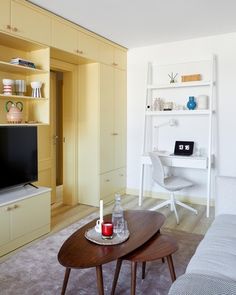 a living room filled with furniture and a flat screen tv sitting on top of a wooden table