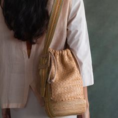 This striking bucket bag is skilfully handwoven from super soft nappa leather, with a handcrafted atta grass base for a chic yet robust finish. Its open top fastens with a drawstring closure and the jacquard shoulder strap can be easily adjusted using the statement side buckle. Each bag comes with its own unique code that connects you to the artisan who handcrafted it for you. Casual Bucket Bag With Braided Details, Natural Bucket Bag With Adjustable Strap For On-the-go, Artisan Handwoven Brown Bucket Bag, Eco-friendly Bucket Bag With Braided Handles, High-end Bohemian Bucket Bag With Braided Handles, Handcrafted Accessories, Leather Bucket, Phone Pouch, Leather Bucket Bag