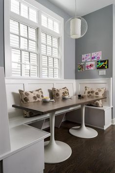 a dining room table and benches with pillows on them