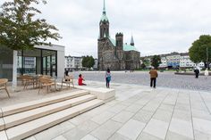 people are walking around in front of a church