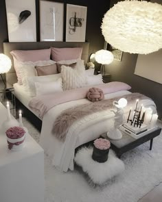 a white bed sitting in a bedroom next to two lamps and pictures on the wall