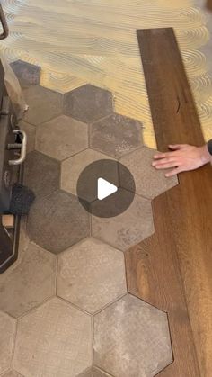 a person is standing on the floor next to a piece of wood that has been cut into hexagonal tiles